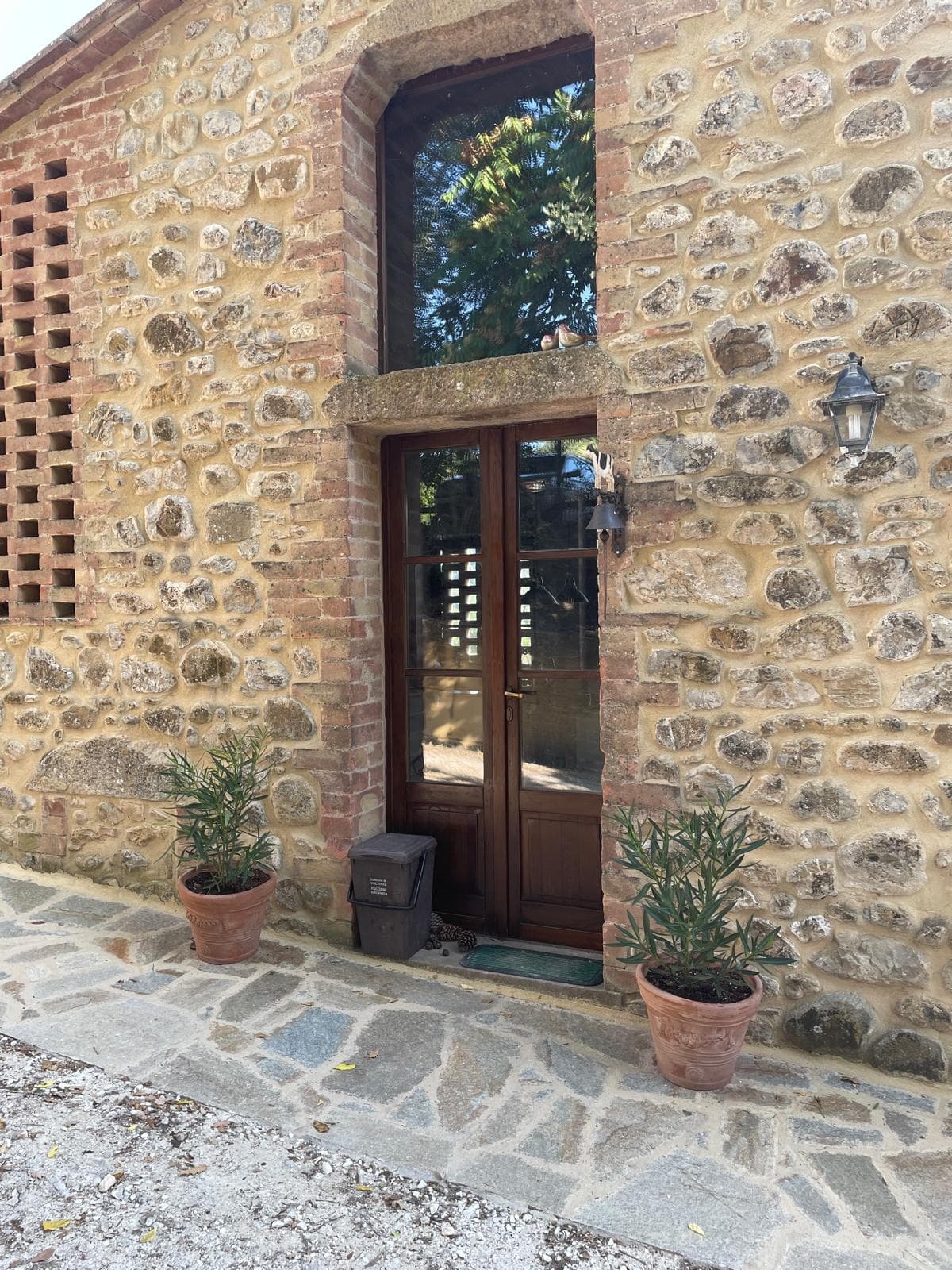 Villa entrance door with terracotta pots on a flagstone path