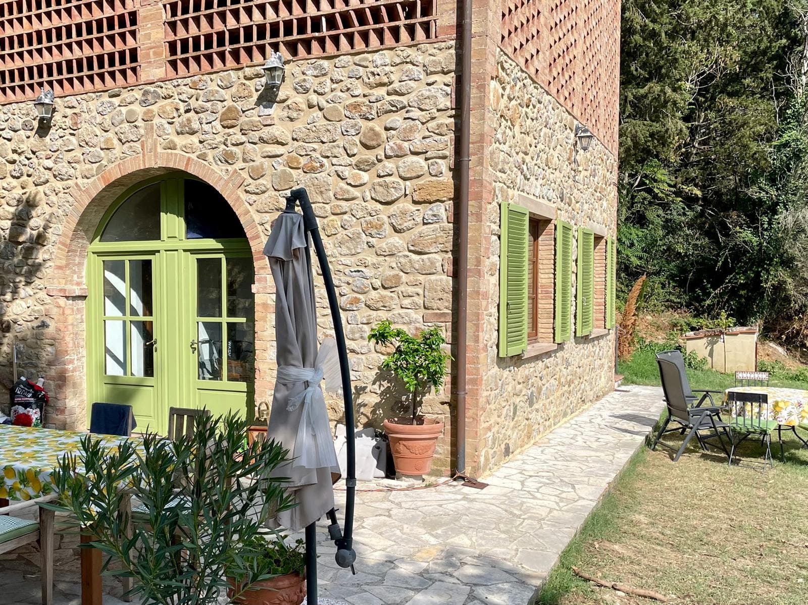 Villa side with patio chairs and terracotta pots
