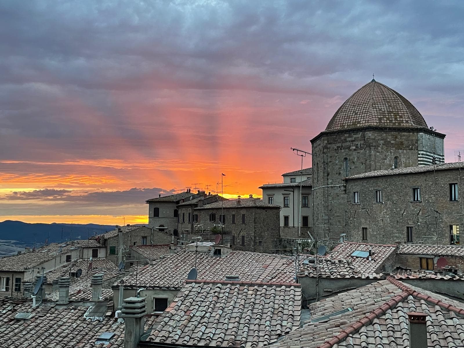 Volterra rooftops and cathedral dome at dramatic sunset
