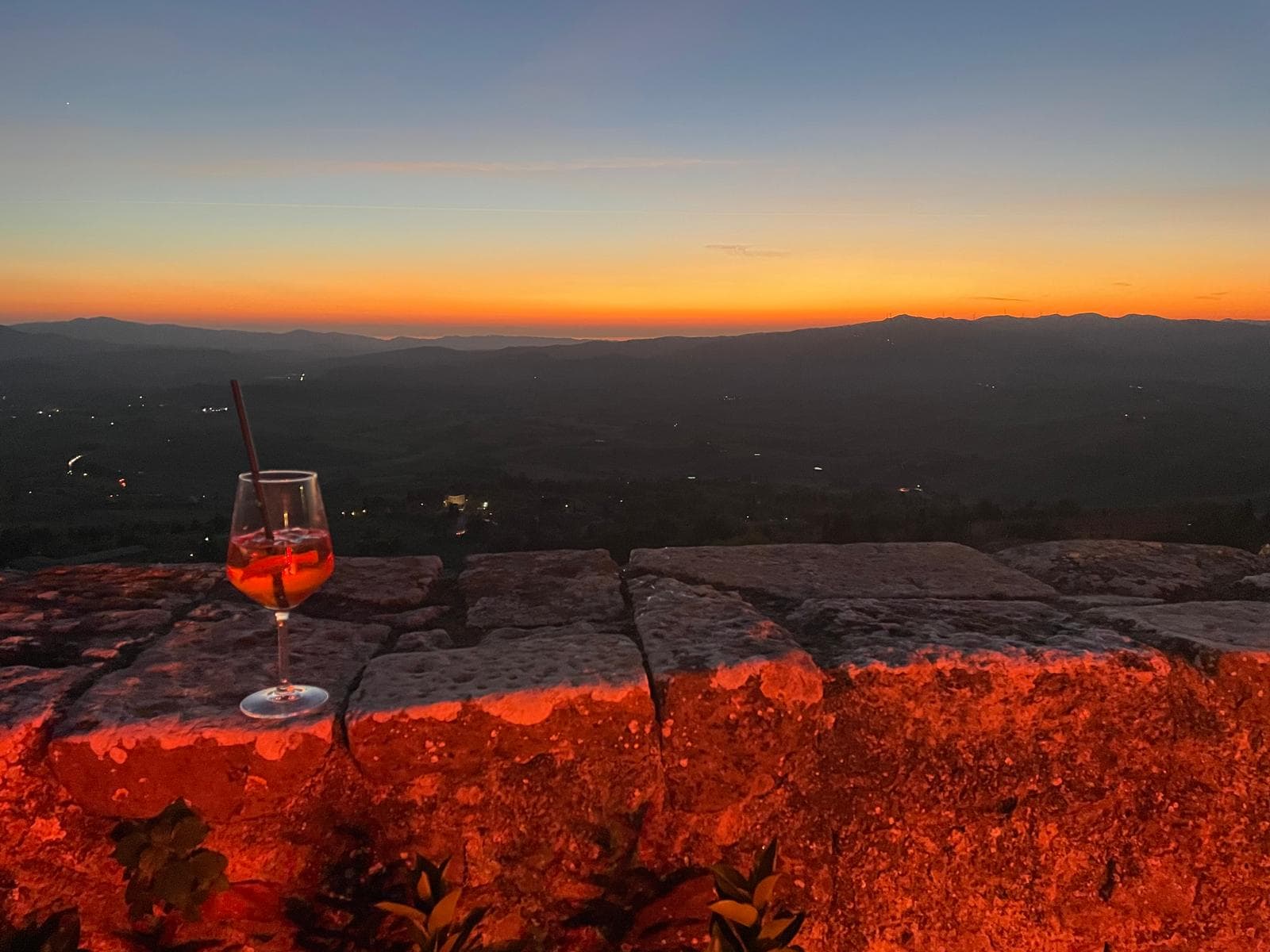 Aperol spritz on an ancient stone wall at Volterra sunset