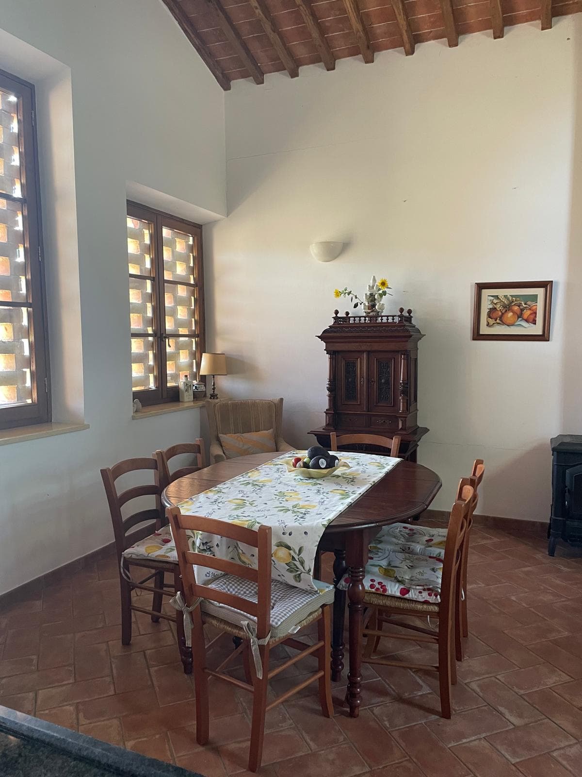 Rustic dining area with an antique sideboard under a beamed ceiling