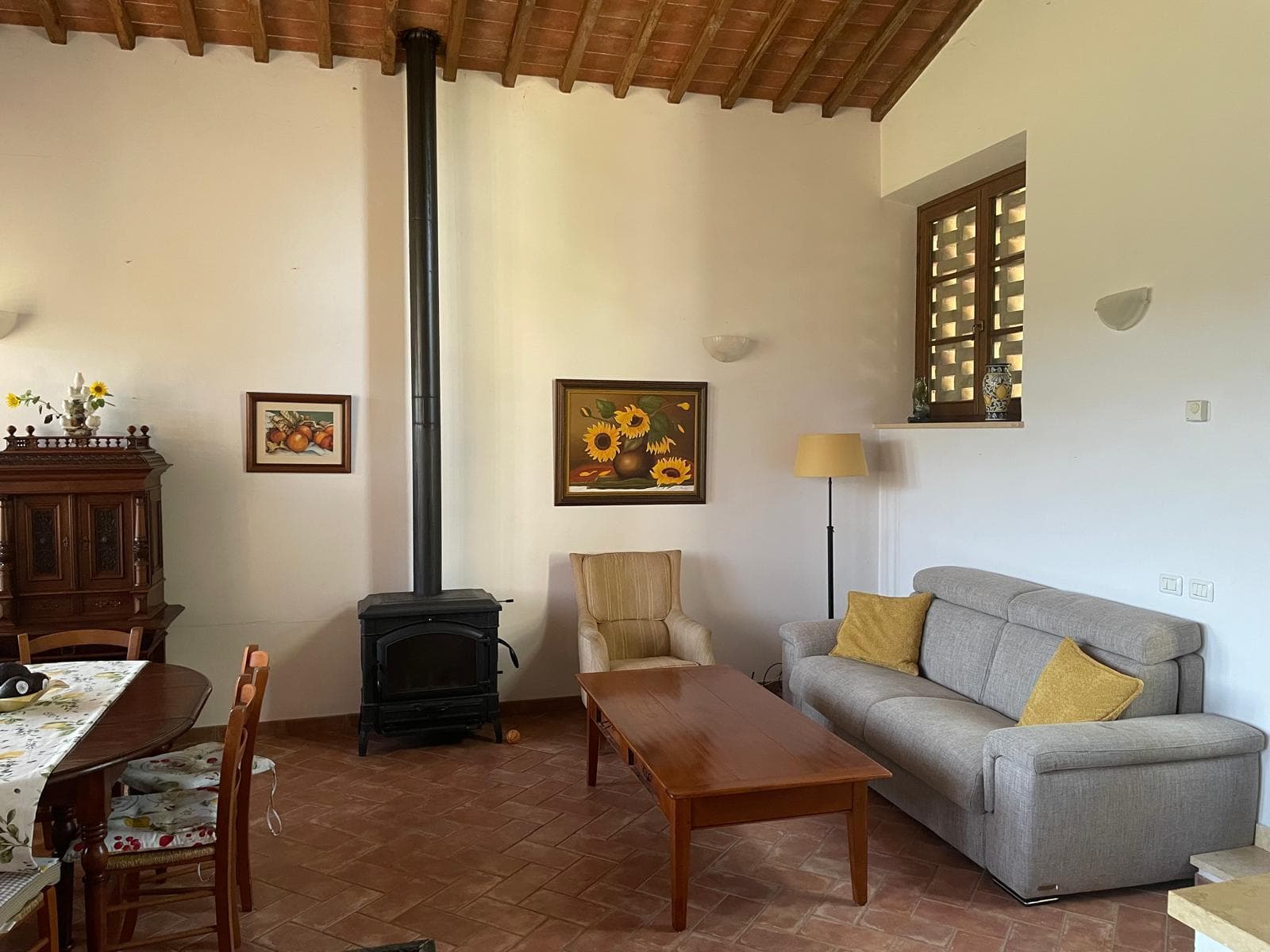 Open-plan living room with wood-burning stove and beamed ceiling
